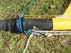 At the lower end, I replaced the mainsail furling line with a somewhat longer one and tied a small block with becket to the end that is passed through the hole. I used a becket block so that I could clip the end of the halyard back to the same block when it was not in use.