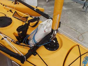 With the jib flaked and then rolled and the jib sheets rolled around the sail, I can stow it against the bulkhead just forward of the Hobie Mirage Drive. It looks like it would interfere with pedaling, but it does not.