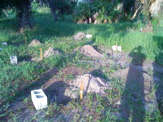 I dug the 6 holes, each one a fair amount bigger than the concrete block that would fill it.