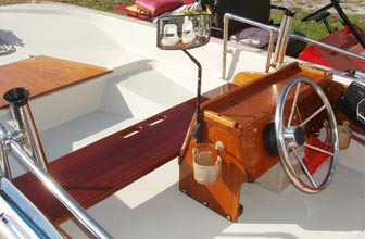 Forward bench seat with grab handle, console with rails, fishing rod holders, water ski mirror