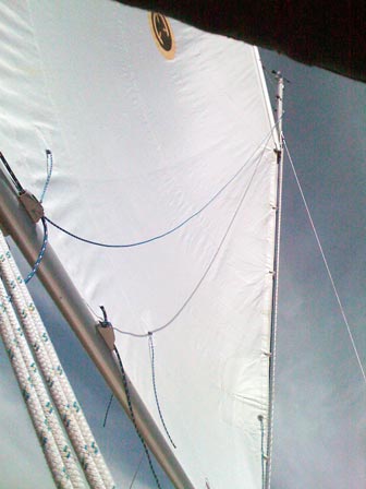 Under sail, showing slack lazy jack line and slack tack reef line